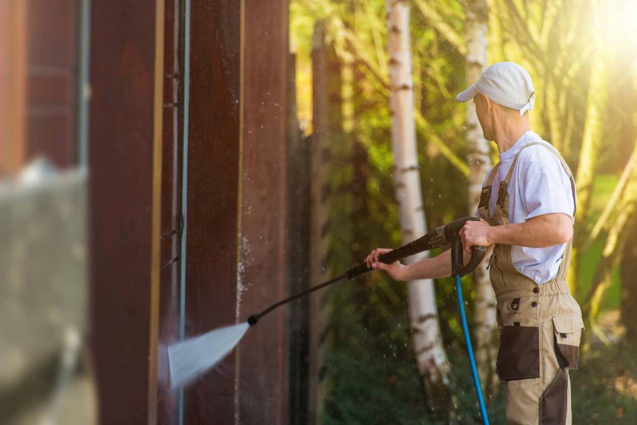 man washing house with pressure cleaner